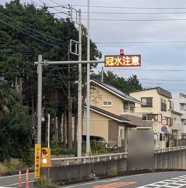 道路脇の柱に付いた電光表示に「冠水注意」の文字が出ている